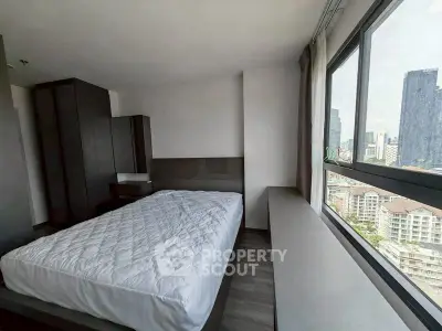 Modern bedroom with large windows offering stunning city views in a high-rise apartment.