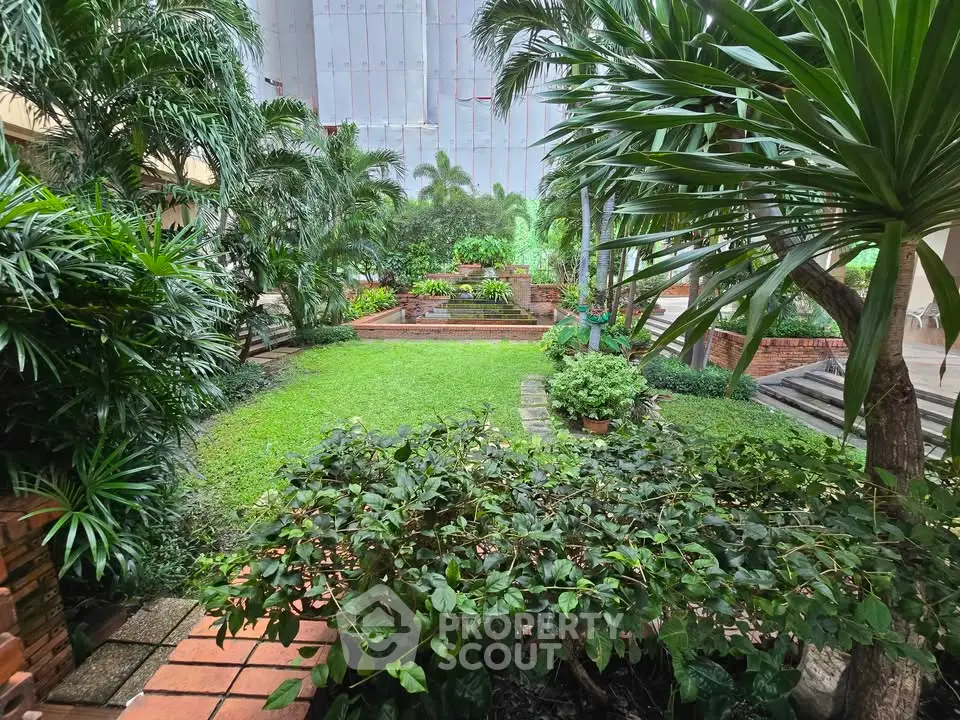Lush green garden with tropical plants in a serene residential setting.