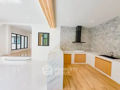 Modern open-layout kitchen with sleek design and wooden accents