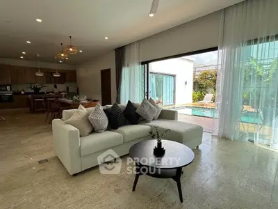 Luxurious open-plan living room with pool view and modern decor