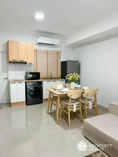 Modern kitchen with dining area, featuring sleek appliances and stylish decor