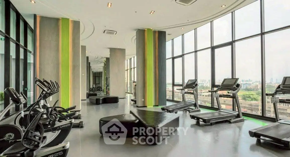 Modern gym with panoramic city views and state-of-the-art equipment in luxury high-rise building.