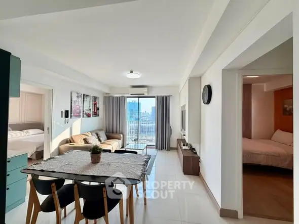 Spacious modern living room with dining area and balcony view in a stylish apartment.