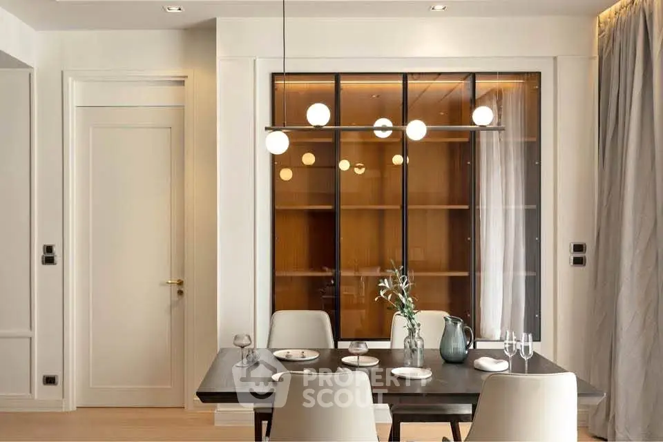Elegant dining area with modern lighting and stylish decor in a contemporary apartment.