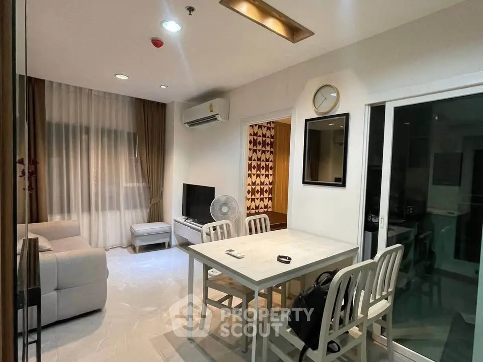 Modern living room with dining area, featuring stylish furniture and bright lighting.