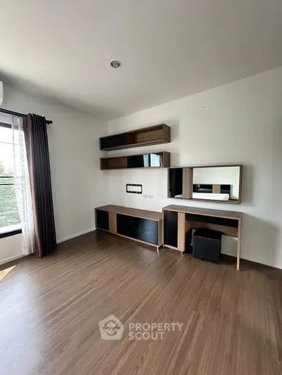 Modern living room with sleek wooden flooring and stylish shelving units