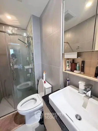 Modern bathroom with glass shower and sleek fixtures in a contemporary apartment.