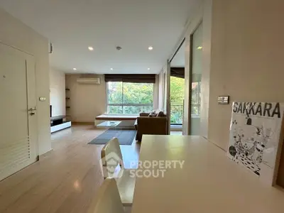 Spacious modern living room with large windows and stylish decor in a bright apartment.