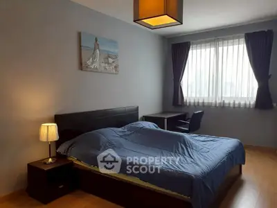Cozy bedroom with modern decor and natural light in a stylish apartment.