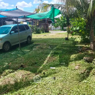 Spacious outdoor garden area with car parking and tropical greenery.