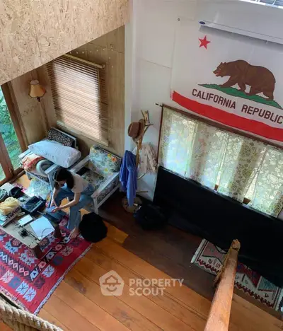 Charming loft with rustic decor and California Republic flag, featuring cozy seating and wooden flooring.