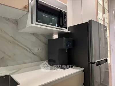 Modern kitchen with sleek appliances and marble backsplash