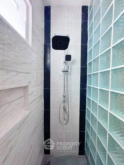 Modern bathroom shower with stylish tile design and glass block wall
