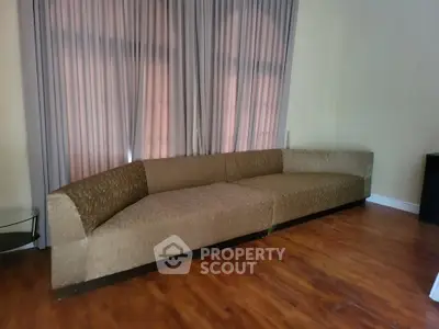 Spacious living room with elegant curved sofa and wooden flooring