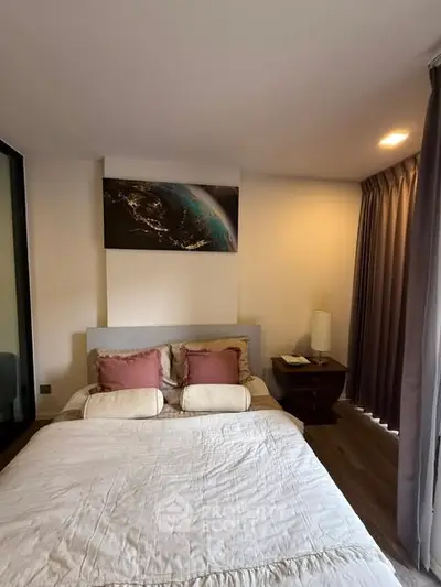 Cozy bedroom with modern decor and ambient lighting, featuring a comfortable bed and stylish artwork.