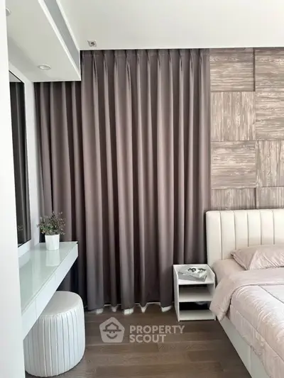Elegant bedroom with modern decor, featuring a stylish bed, side table, and luxurious curtains.