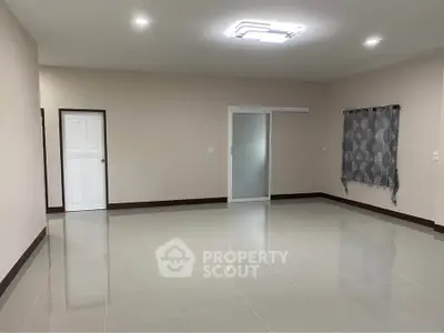 Spacious empty room with modern lighting and tiled flooring, perfect for customization.