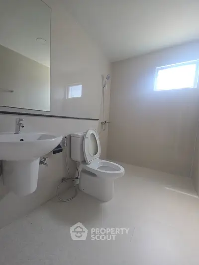 Spacious modern bathroom with sleek fixtures and natural light.