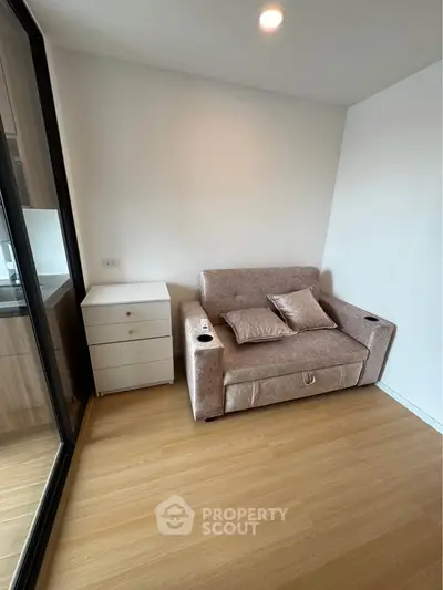 Cozy living room with plush sofa and modern wooden flooring in a stylish apartment.