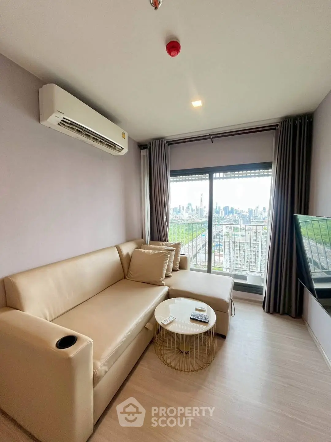 Modern living room with city view, beige sofa, and sleek decor
