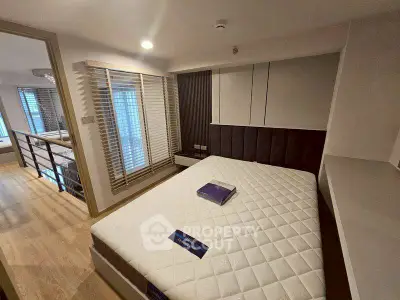 Modern bedroom with large window and stylish decor in a contemporary apartment.