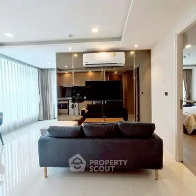 Modern living room with sleek design, featuring a large TV, comfortable sofa, and open layout with natural light.