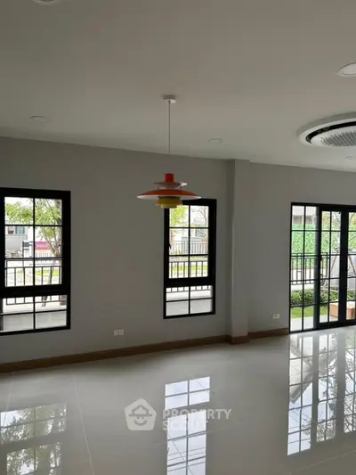 Spacious modern living room with large windows and stylish lighting