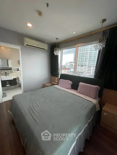 Spacious bedroom with large window and city view, featuring elegant lighting and modern decor.