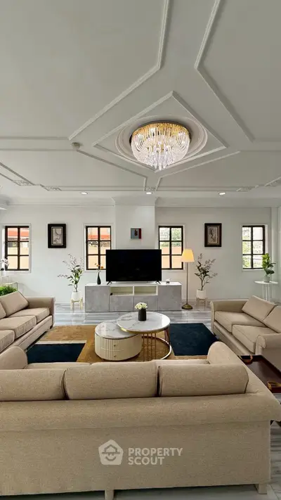 Luxurious living room with elegant chandelier and modern furnishings, perfect for sophisticated gatherings.