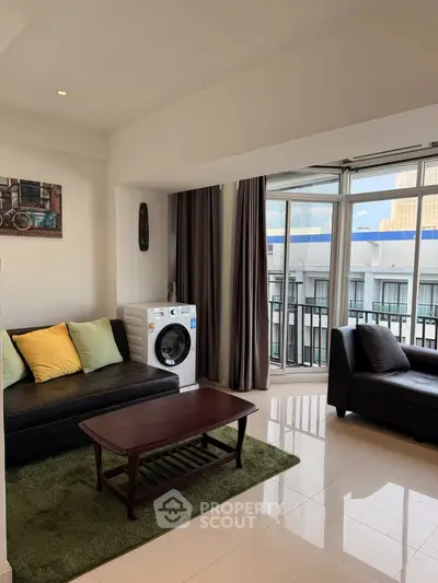 Spacious living room with modern decor and balcony access in urban apartment.