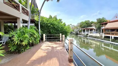 Stunning waterfront property with spacious balcony and lush greenery, perfect for serene living.