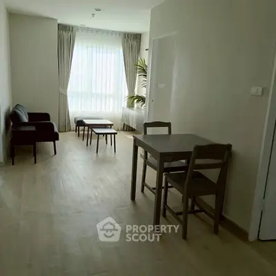 Spacious living room with modern furniture and large window for natural light.