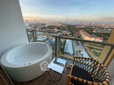 Luxurious balcony with jacuzzi offering stunning cityscape views at sunset.