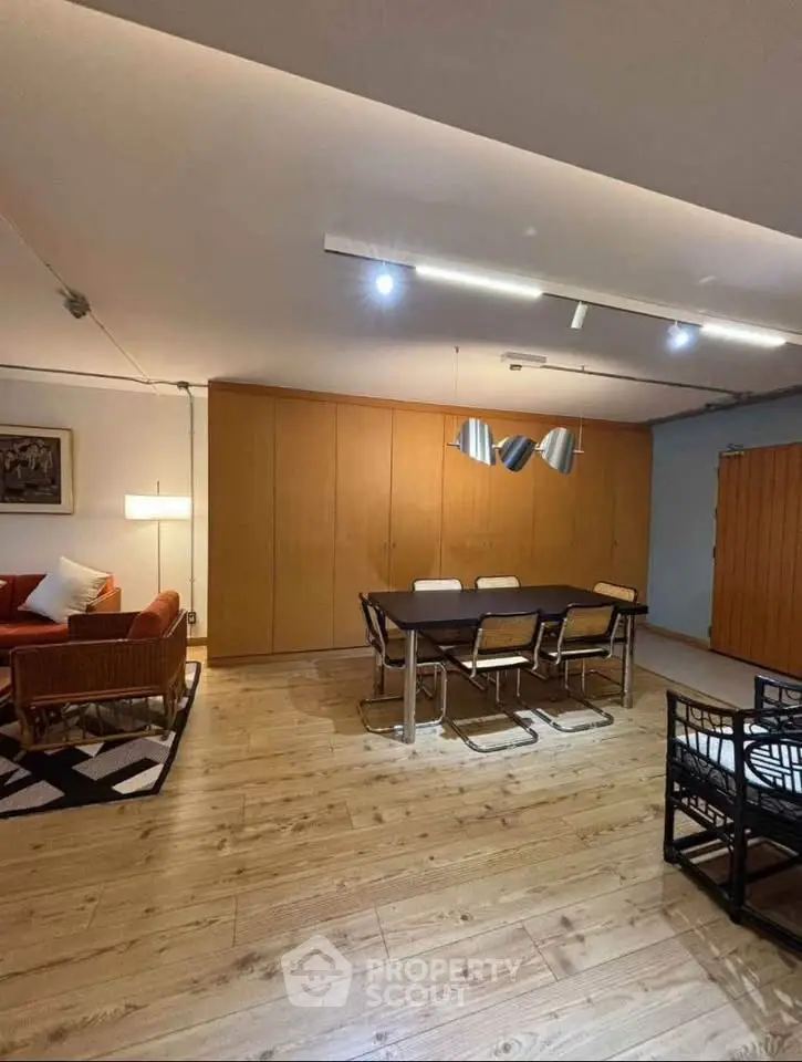 Spacious modern living room with wooden flooring and stylish dining area.