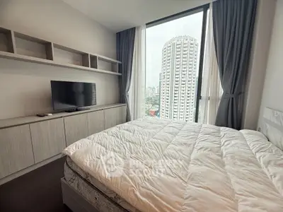 Modern bedroom with city view, featuring a cozy bed and sleek TV setup.