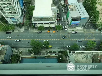 Stunning aerial view of urban street with modern buildings and lush greenery, perfect for city living enthusiasts.