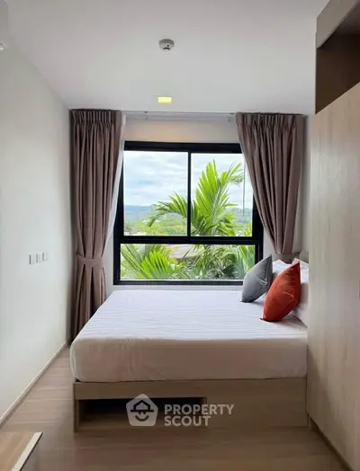 Modern bedroom with large window and scenic view, featuring cozy bed and stylish decor.