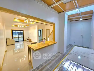 Modern open-plan living area with stylish lighting and wooden accents
