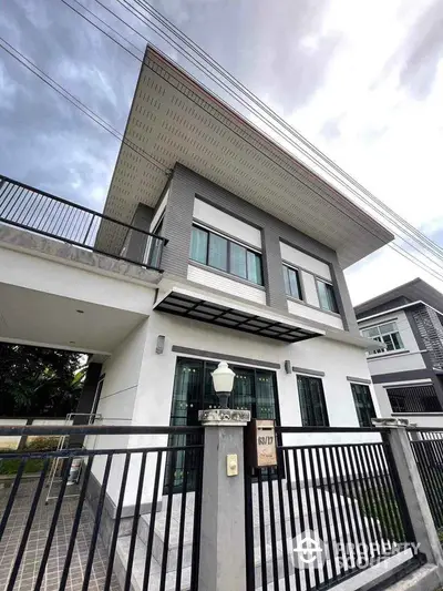 Modern two-story house with sleek design and spacious balcony in a suburban neighborhood.