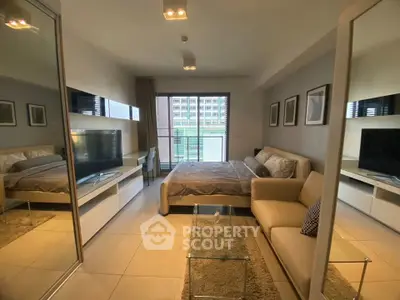 Modern studio apartment with cozy living area and large window view.