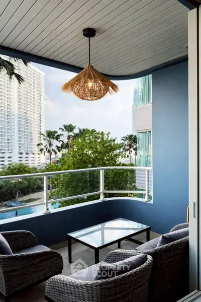 Chic balcony with modern wicker furniture and stunning city view, perfect for relaxation.