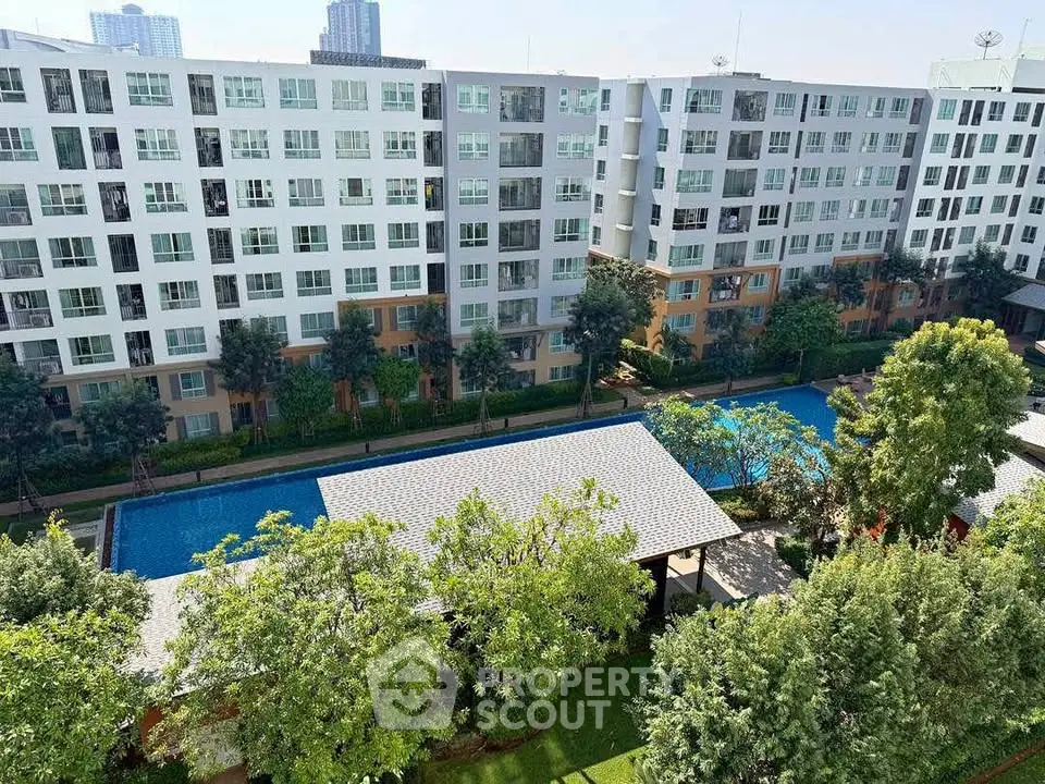 Modern apartment complex with pool and lush greenery, offering a serene urban living experience.