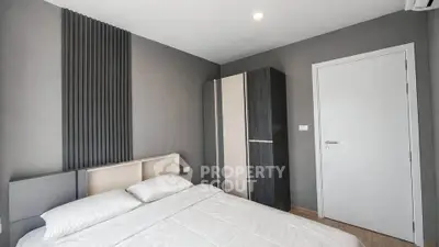 Modern minimalist bedroom with sleek design and neutral tones, featuring a stylish wardrobe and cozy bed.