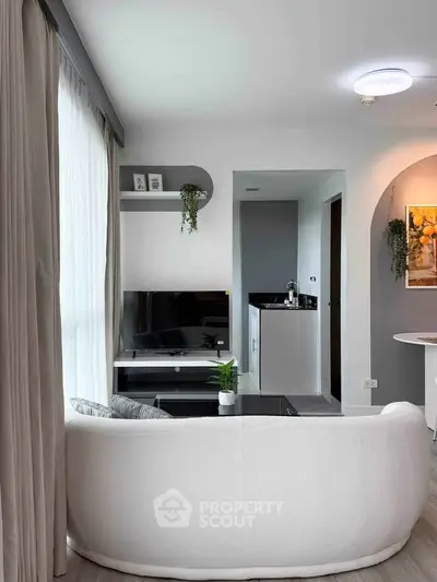 Modern living room with sleek design, cozy white sofa, and stylish decor, perfect for urban living.