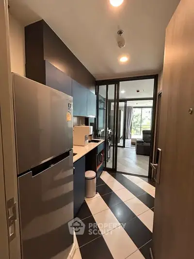 Modern kitchen with sleek appliances and open layout leading to a spacious living area.