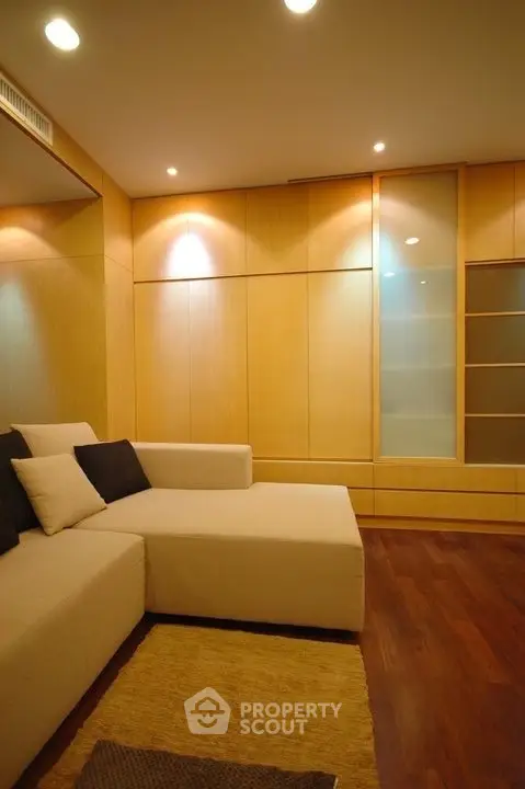 Modern living room with stylish beige sofa and wooden paneling