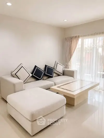 Elegant living room with modern beige sofa and natural light