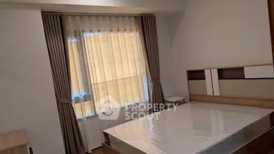 Cozy bedroom with natural light and modern furnishings, perfect for relaxation and comfort.