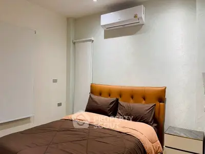 Cozy bedroom with modern air conditioning and stylish brown bedding