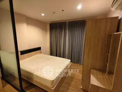 Spacious bedroom with modern wooden furniture and large window for natural light.